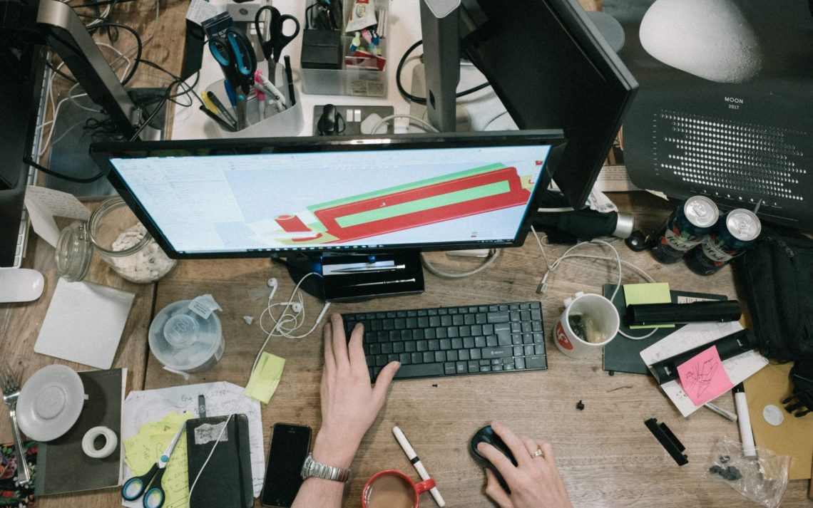 A messy computer desk viewed from above.