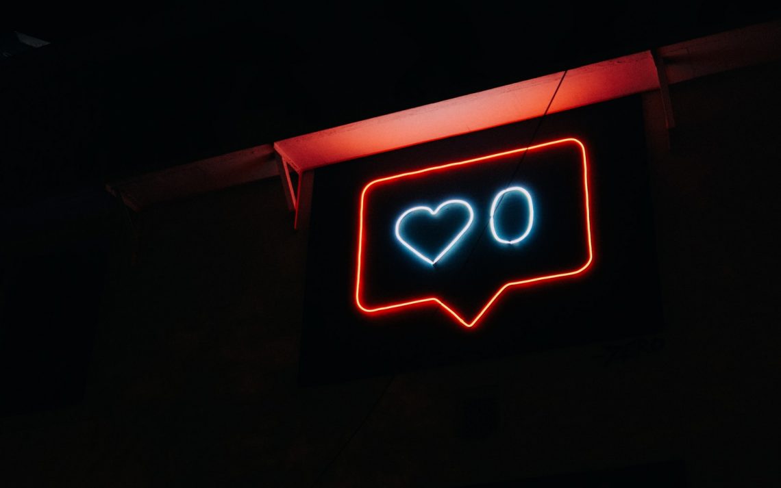 A neon sign that shows a 'like' button notification with a heart and the number zero.