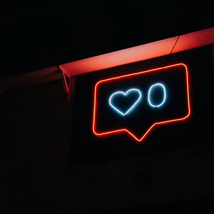A neon sign that shows a 'like' button notification with a heart and the number zero.